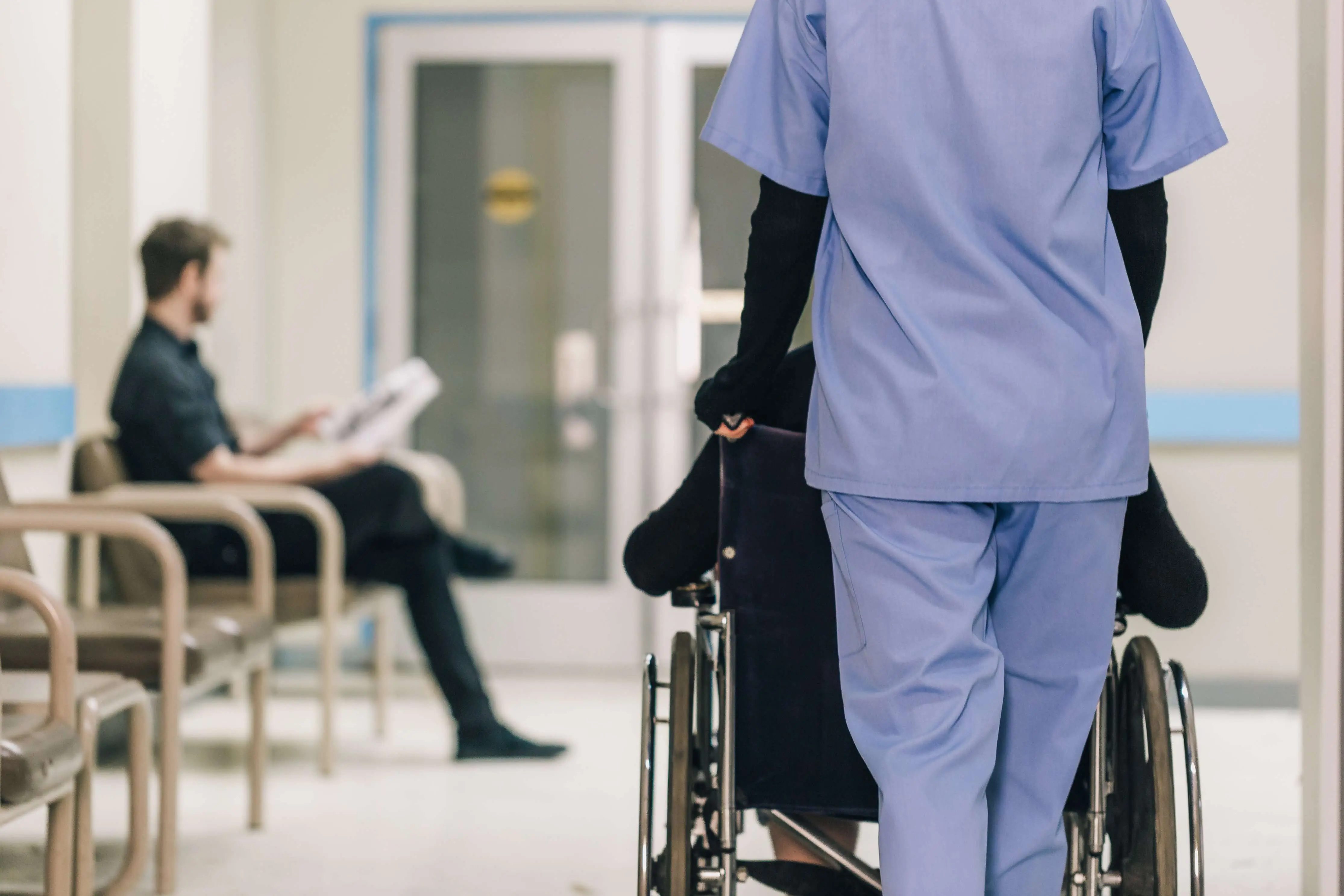 The LPN Wheels a Patient Down Hospital Hallway