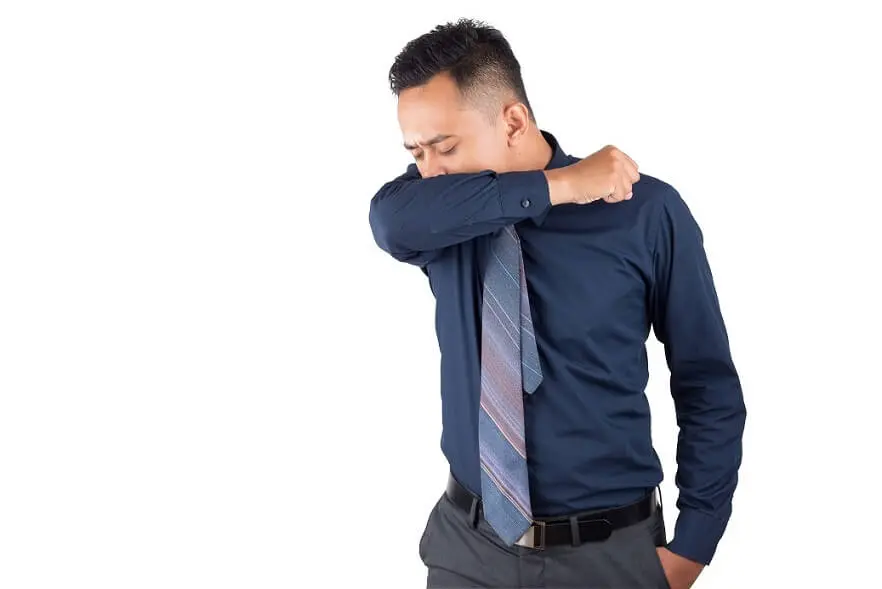 Business Man Coughs and Sneezes into his Shirt Sleeve