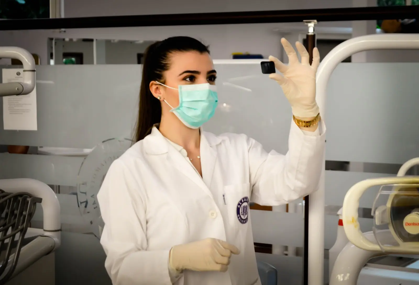 Young healthcare technician wearing mask reviews patient's medical image