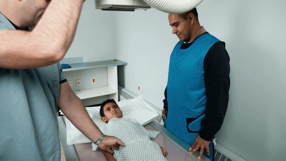 X-Ray Technicians work with a child using X-Ray equipment 