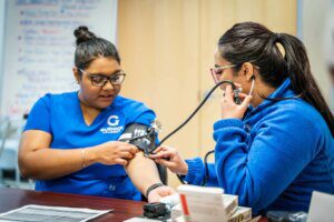 One student medical assistant practices on the other. 